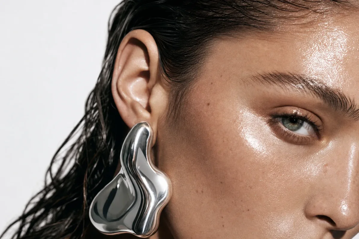 RARE FORM jewelry campaign: sculptural silver earring against dewy skin